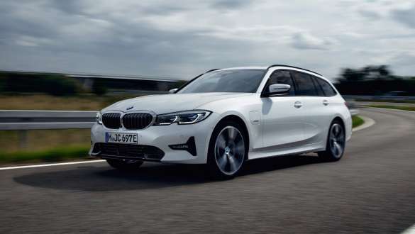 Plug-in hybrid BMW 3 Series Touring 2021 G21 three-quarter front view driving Plug-in hybrid BMW 3 Series Touring 2021 G21 three-quarter front view driving on the street