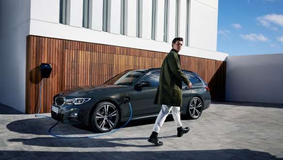 Plug-in hybrid BMW Series Touring 2021 G21 three-quarter side view on BMW Wallbox Plug-in hybrid BMW Series Touring 2021 G21 three-quarter side view on BMW Wallbox with model