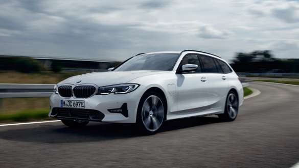 Plug-in hybrid BMW 3 Series Touring 2021 G21 three-quarter front view driving Plug-in hybrid BMW 3 Series Touring 2021 G21 three-quarter front view driving on the street