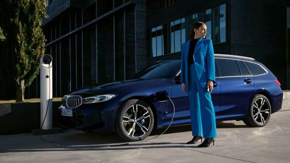 BMW 3 Series Touring plug-in hybrid G21 three-quarter side view charging BMW 3 Series Touring plug-in hybrid G21 three-quarter side view charging with model