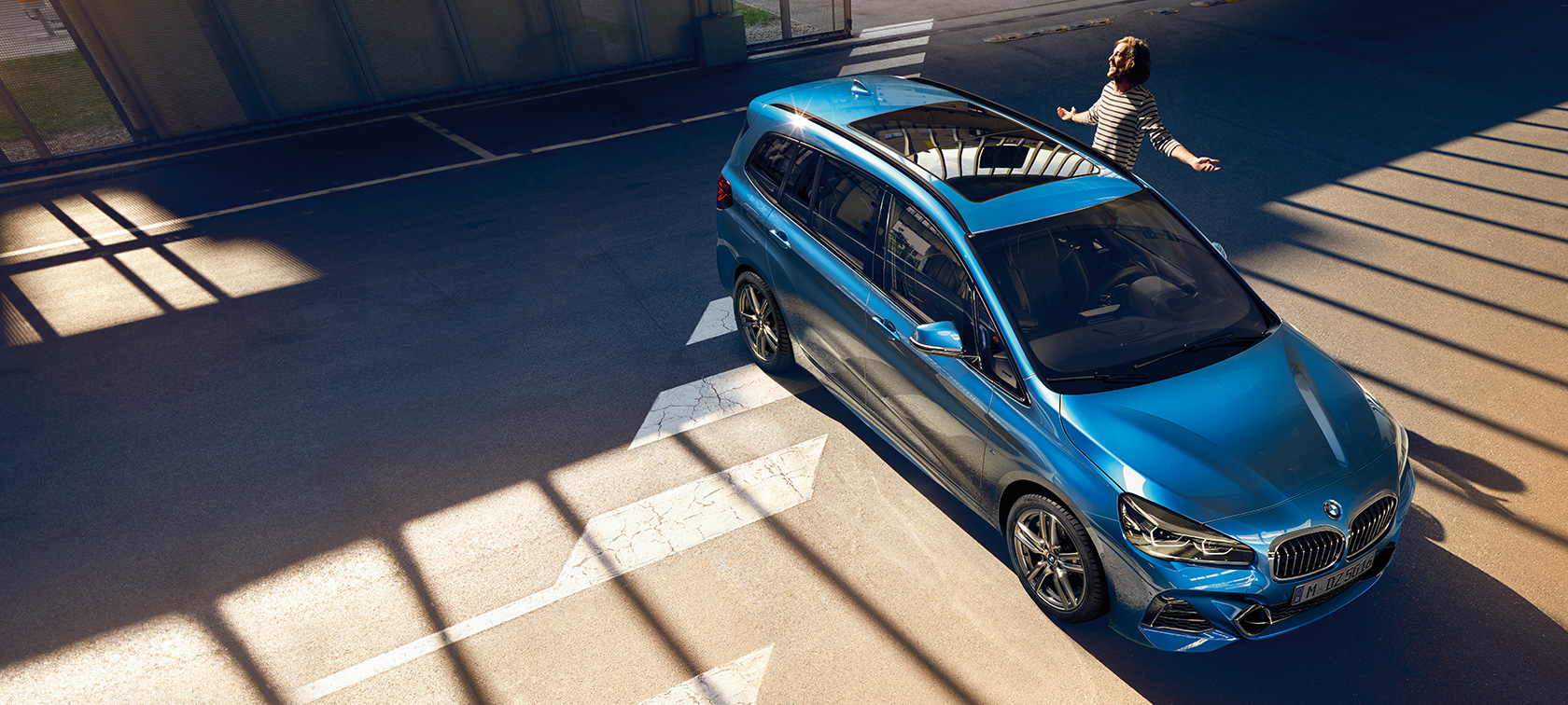 Family standing next to BMW 2 Series Gran Tourer F46 2018 Misano Blue metallic