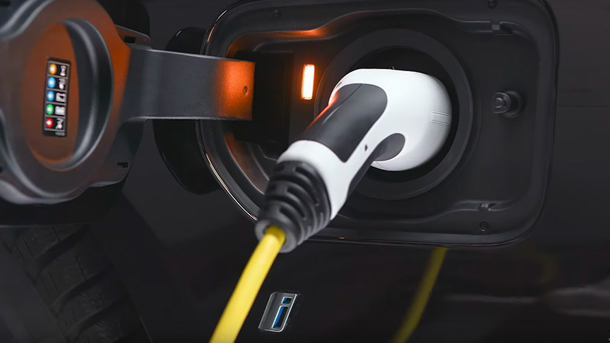 BMW plug-in hybrid connected with charging cable BMW plug-in hybrid connected with charging cable close-up