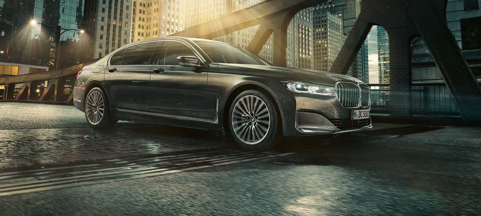 BMW 7 Series Sedan G11 G12 2019 side view BMW 7 Series Sedan G11 G12 2019 Bernina Grey Amber Effect in urban setting three-quarter side view