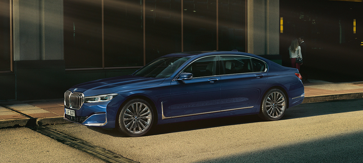 BMW 7 Series Sedan G11 G12 BMW Individual Aventurine Red metallic side view BMW 7 Series Sedan G11 G12 BMW Individual Aventurine Red metallic side view in urban setting