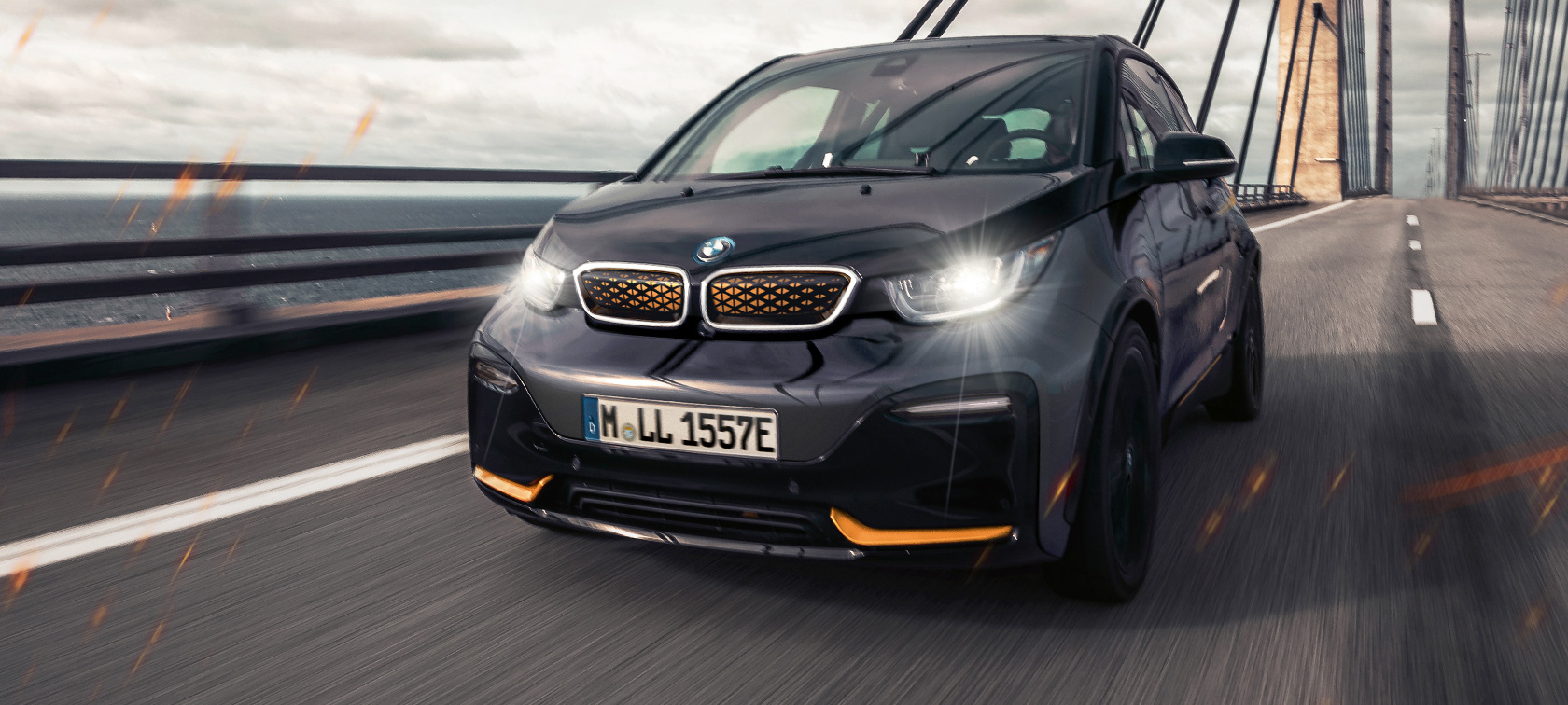 BMW i3 Unique Forever Edition I01 three-quarter front view BMW i3 Unique Forever Edition I01 Storm Bay with Frozen E-Copper metallic accent three-quarter front view driving on highway