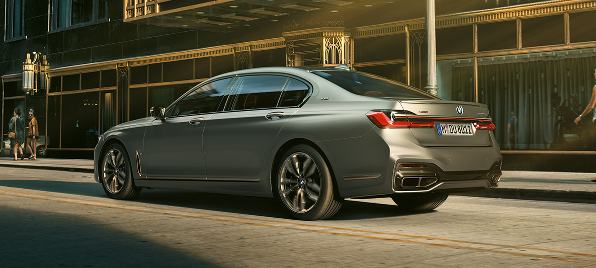 BMW M760Li xDrive Sedan G11 G12 2019 Frozen Dark Silver metallic three-quarter side view driving in urban setting BMW M760Li xDrive Sedan G11 G12 2019 Frozen Dark Silver metallic three-quarter side view driving in urban setting