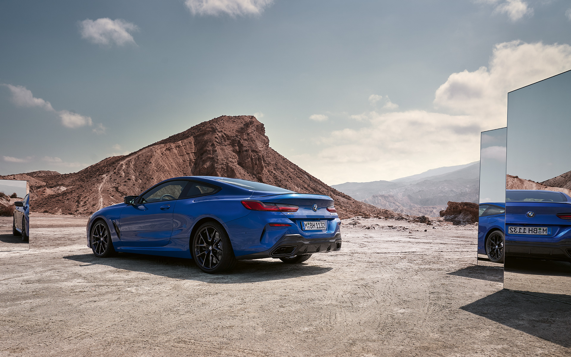 The BMW M850i xDrive Coupé G15 LCI Facelift 2022 rear view standing The BMW M850i xDrive Coupé G15 LCI Facelift 2022 M Portimao Blue metallic rear view standing with mirrors