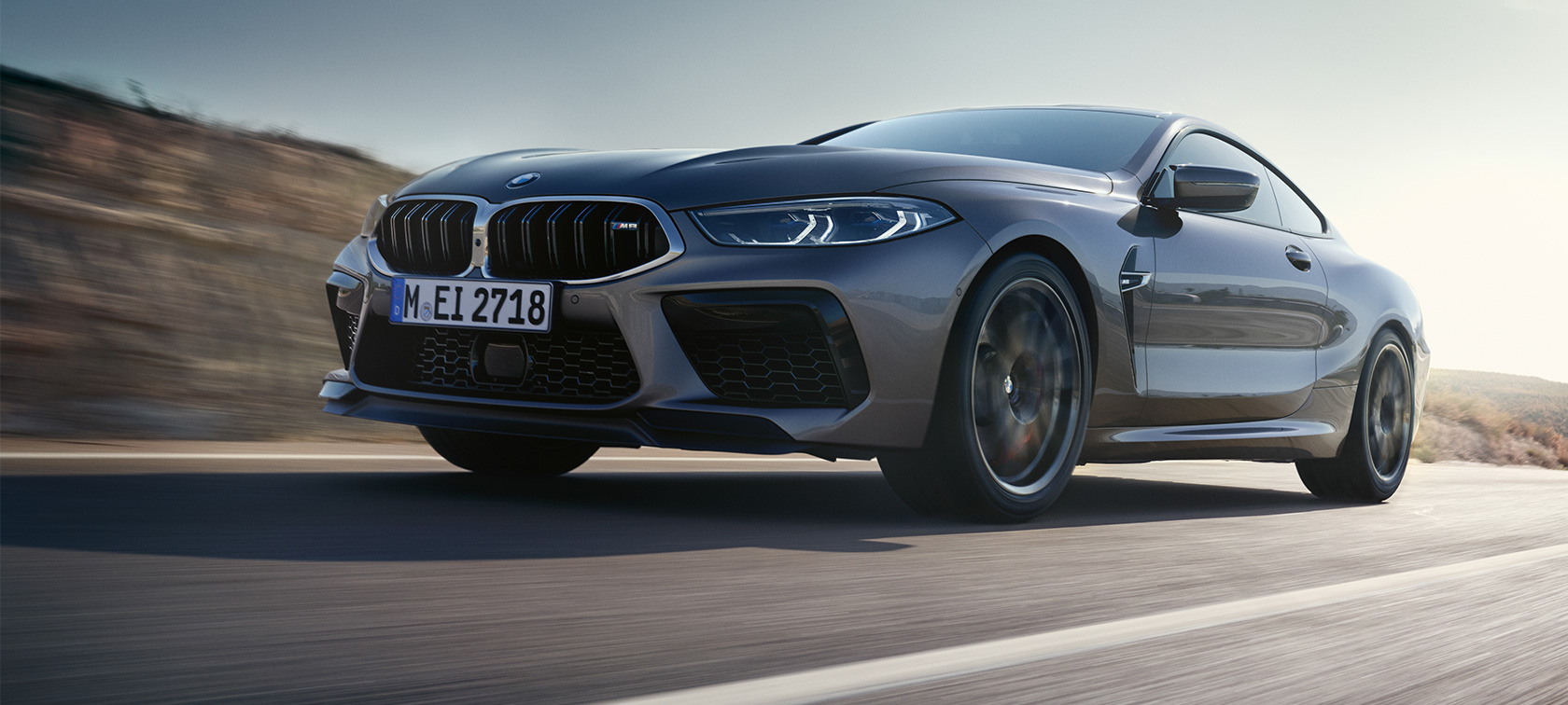 The BMW M8 Coupé F92 LCI Facelift 2022 three-quarter side view driving The BMW M8 Coupé F92 LCI Facelift 2022 Skyscraper grey metallic three-quarter side view low angle shot