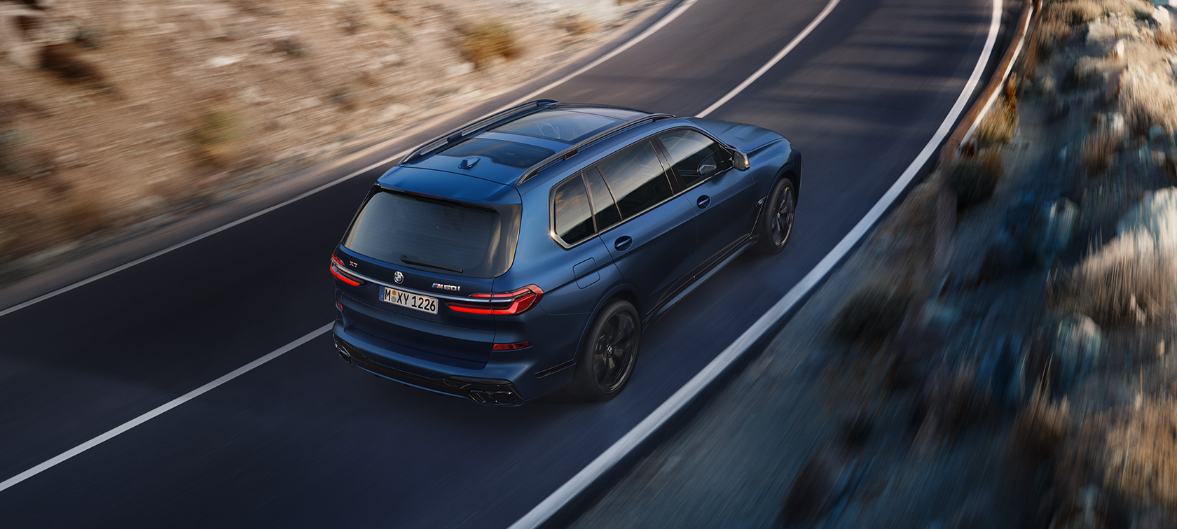 BMW X7 M60i xDrive G07 LCI Frozen Marina Bay Blue three-quarter rear view bird’s-eye view driving BMW X7 M60i xDrive G07 LCI Frozen Marina Bay Blue three-quarter rear view bird’s-eye view driving on the street