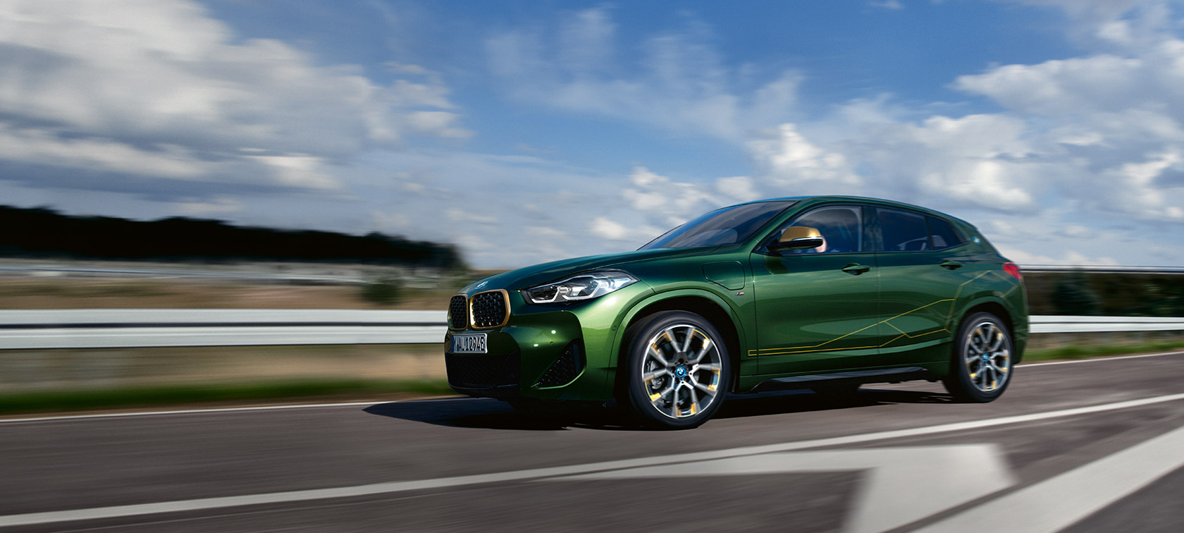 Three-quarter side view driving BMW X2 F39 Sanremo Green metallic