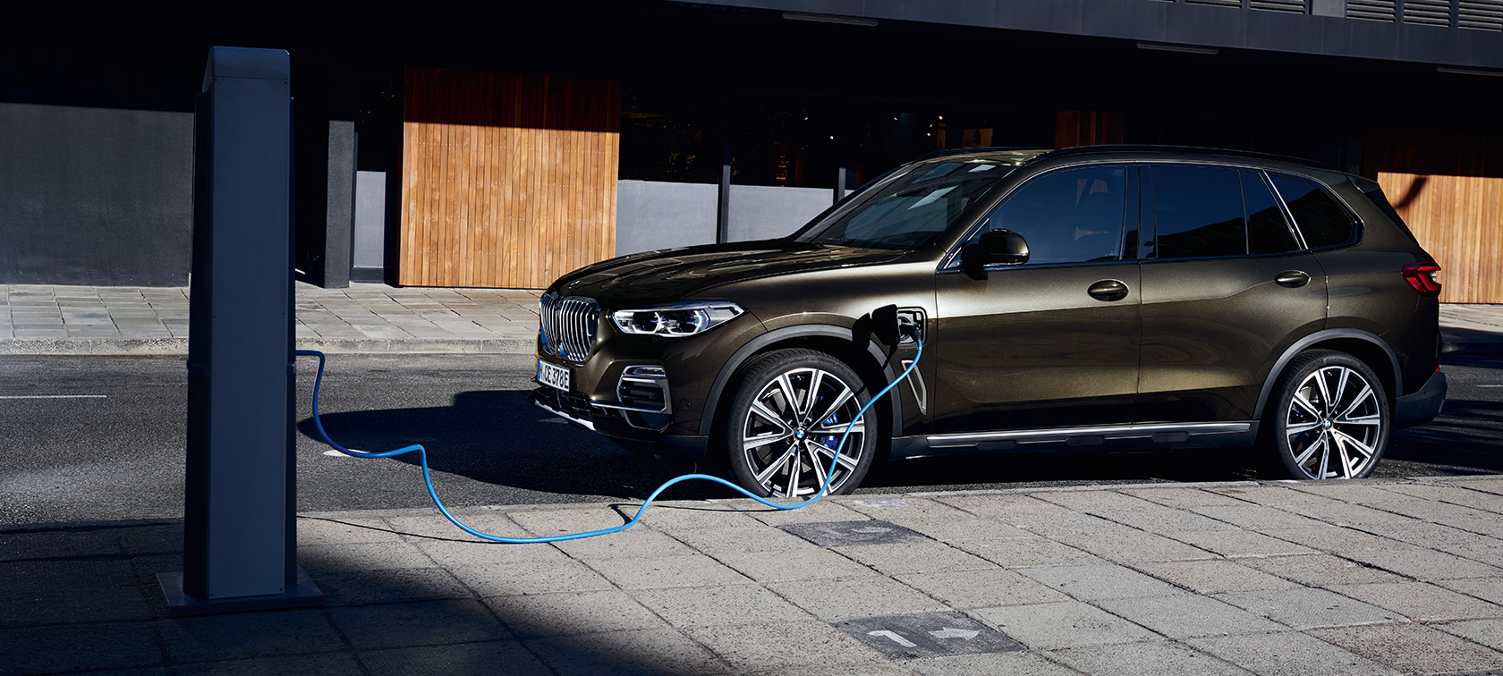 Plug-in hybrid BMW X5 xDrive45e G05 three-quarter side view Plug-in hybrid BMW X5 xDrive45e G05 three-quarter side view charging