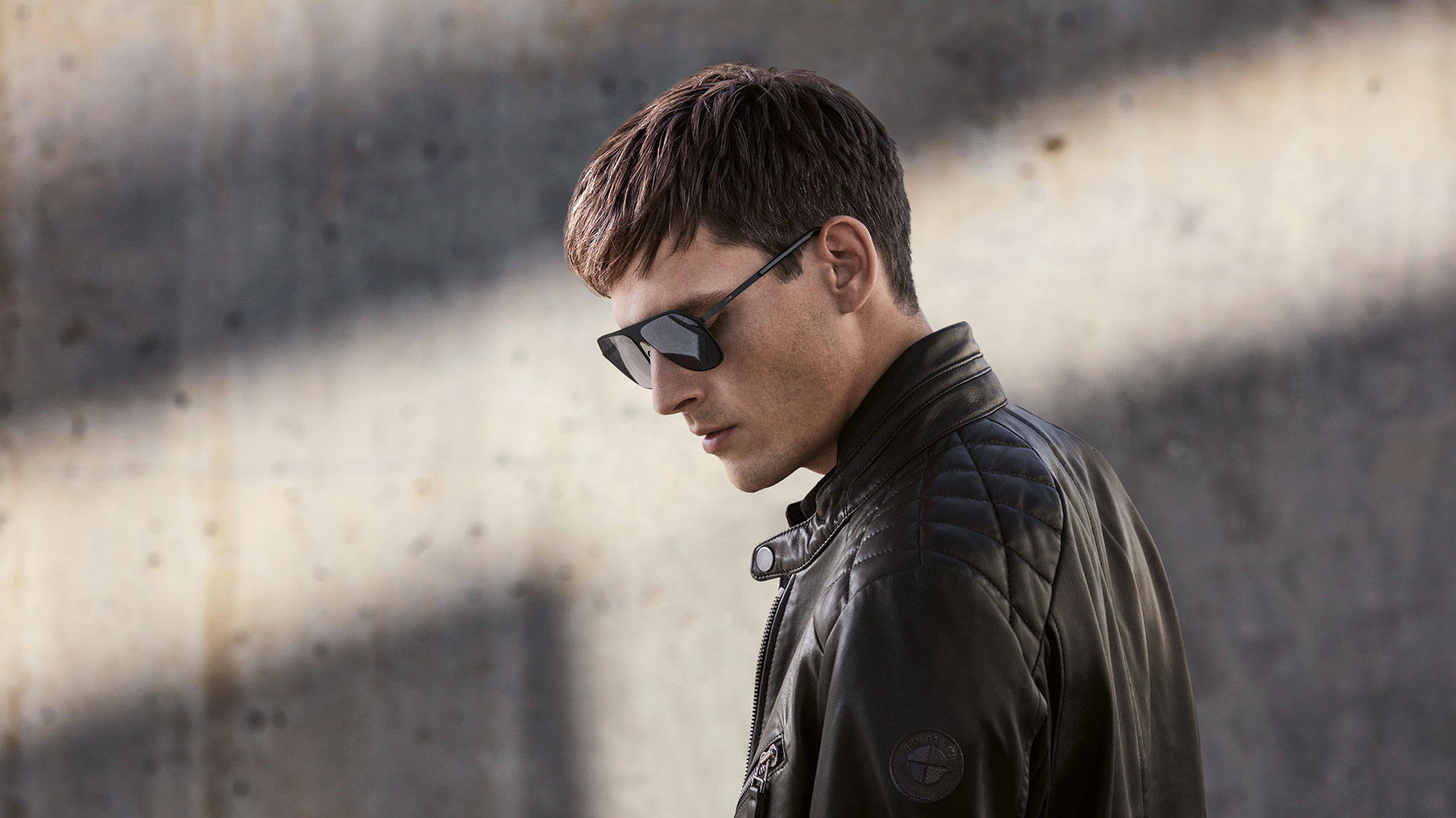 BMW Men’s Leather Jacket. Side-profile shot of a man wearing the BMW Men's Leather Jacket from the BMW Collection.