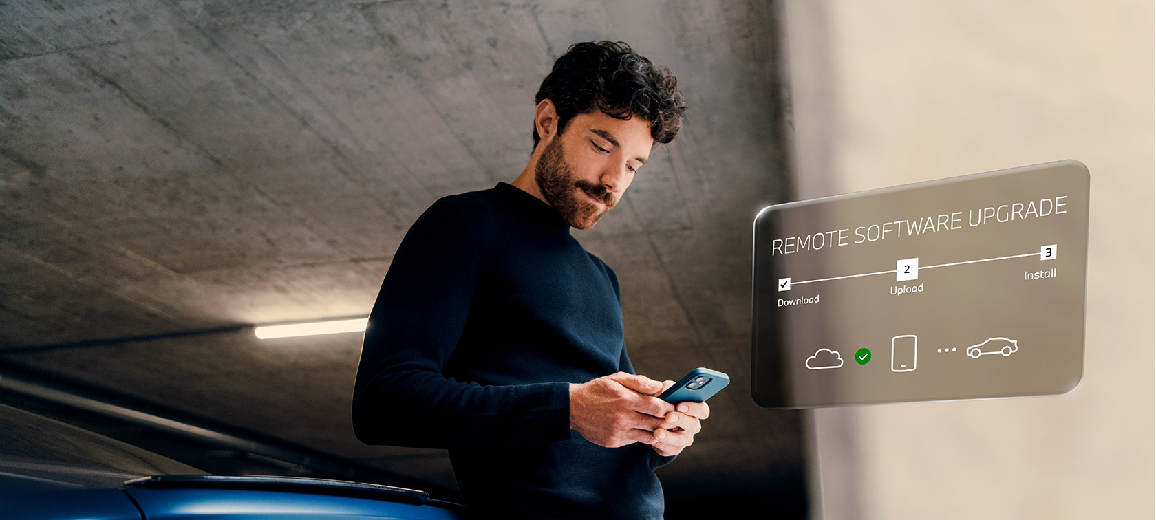 Man in front of BMW looking at his smartphone Remote Software Upgrade Man in front of BMW looks at his smartphone