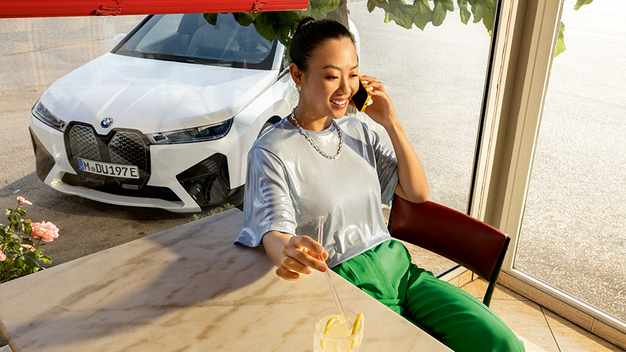 Requirements Proactive Care Proactive Care, Check-up & Maintenance Requirements Proactive Care Proactive Care, Check-up & Maintenance Woman sitting at table with smartphone in hand and BMW vehicle in background